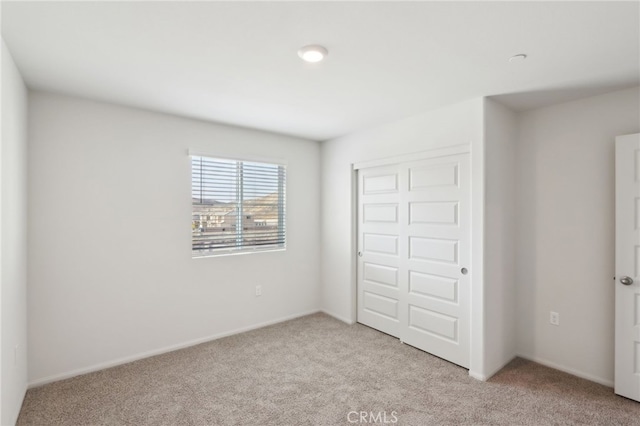 unfurnished bedroom featuring a closet and light carpet