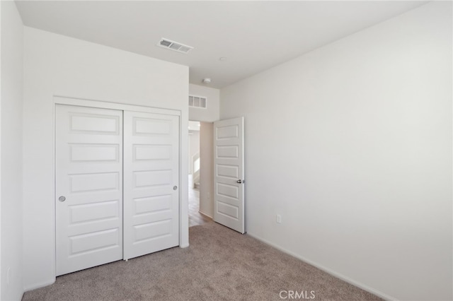 unfurnished bedroom featuring a closet and light carpet