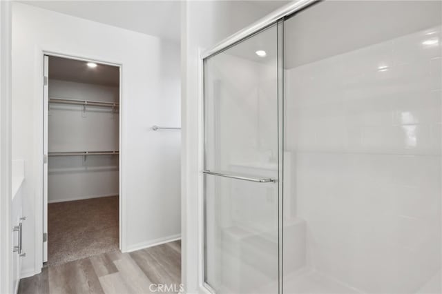 bathroom featuring hardwood / wood-style flooring and a shower with shower door