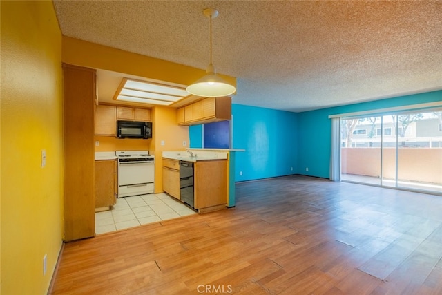 kitchen featuring light hardwood / wood-style flooring, a textured ceiling, hanging light fixtures, kitchen peninsula, and black appliances