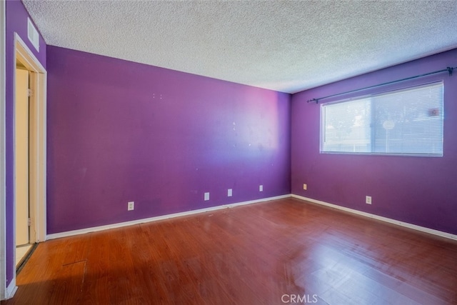 unfurnished room featuring hardwood / wood-style floors and a textured ceiling