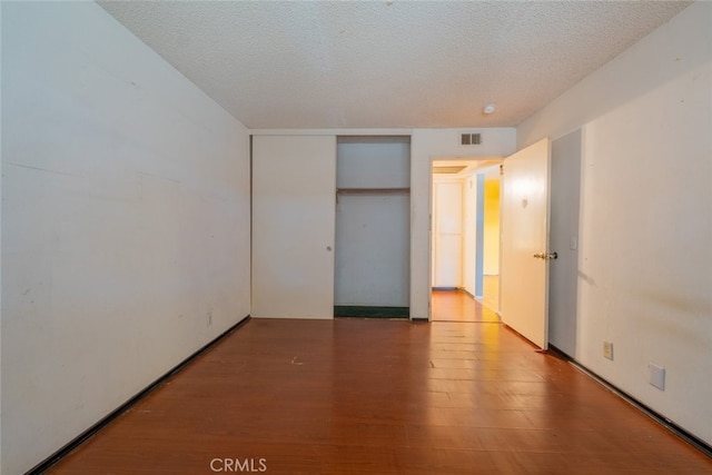 unfurnished bedroom featuring wood-type flooring and a textured ceiling