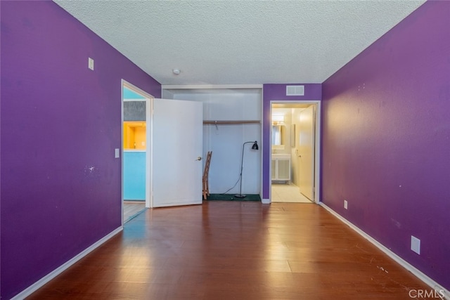 unfurnished bedroom featuring hardwood / wood-style floors and a textured ceiling