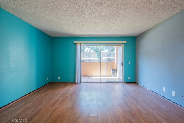 empty room featuring a textured ceiling and light wood-type flooring