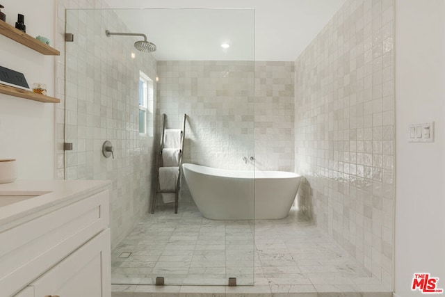 bathroom with shower with separate bathtub, tile walls, and vanity