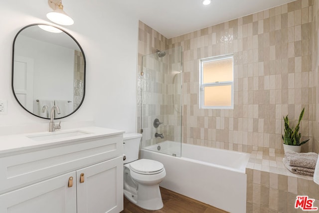 full bathroom with tiled shower / bath combo, vanity, and toilet