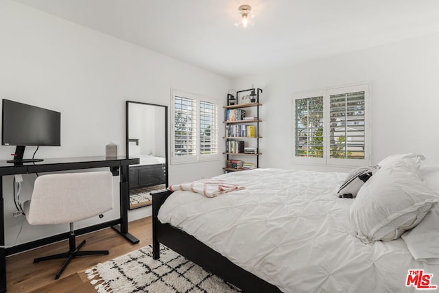 bedroom with multiple windows and light wood-type flooring