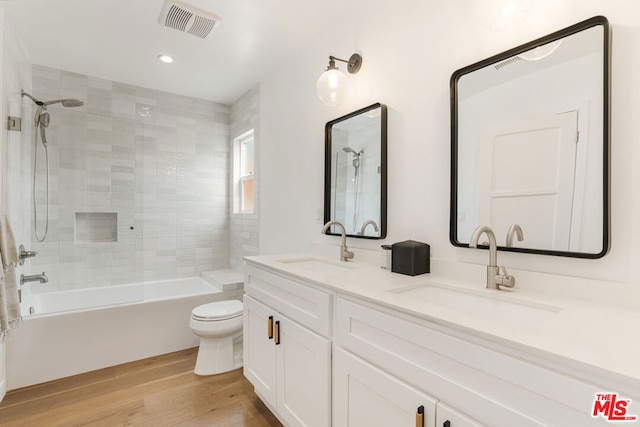 full bathroom featuring toilet, wood-type flooring, bathtub / shower combination, and vanity