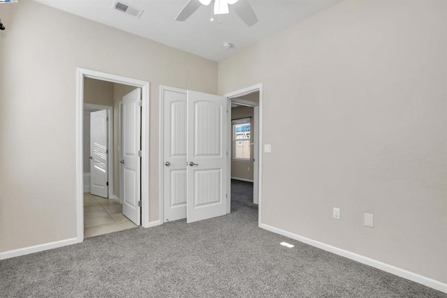 unfurnished bedroom featuring light carpet and ceiling fan