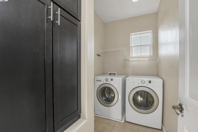 washroom with washer and dryer and light tile patterned floors