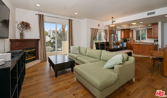 living room with a chandelier and light hardwood / wood-style flooring