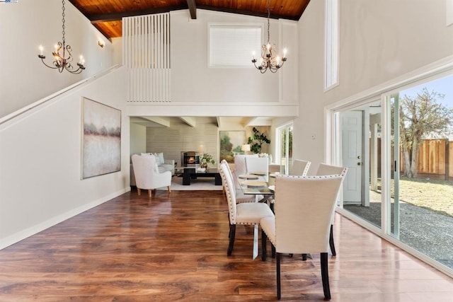 dining area with hardwood / wood-style flooring, an inviting chandelier, and beamed ceiling