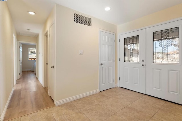 foyer entrance featuring light tile patterned floors and french doors