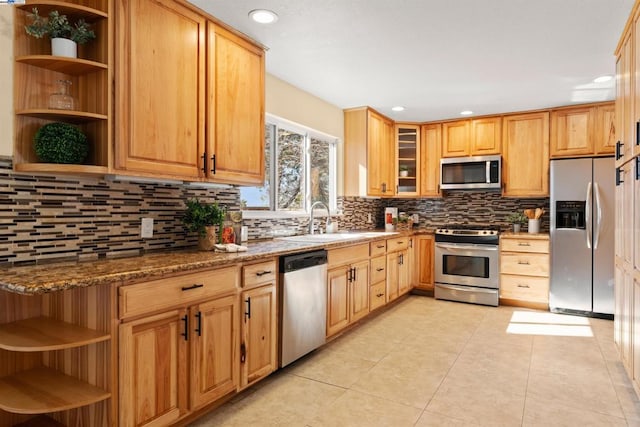 kitchen featuring tasteful backsplash, appliances with stainless steel finishes, sink, and dark stone counters