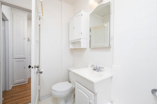 bathroom with vanity, toilet, and hardwood / wood-style floors