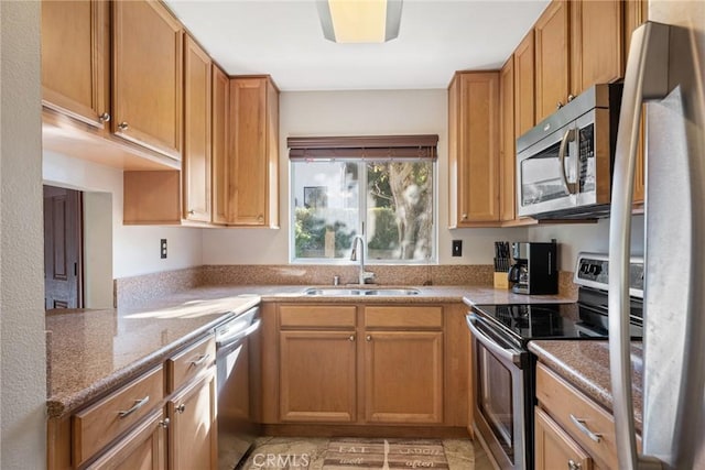 kitchen featuring light stone counters, sink, and appliances with stainless steel finishes