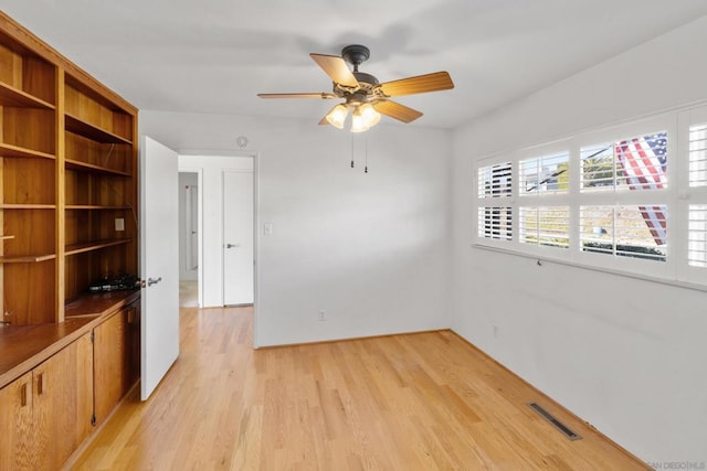 empty room with ceiling fan and light wood-type flooring