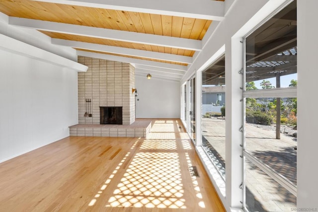 unfurnished sunroom featuring a brick fireplace, wood ceiling, and lofted ceiling with beams