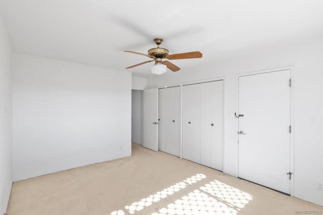 unfurnished bedroom featuring light colored carpet and ceiling fan