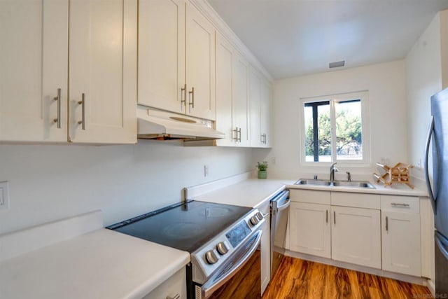 kitchen featuring dark hardwood / wood-style flooring, sink, stainless steel appliances, and white cabinets