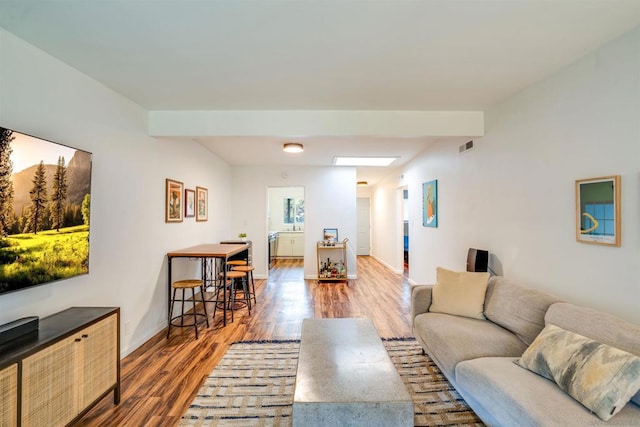 living room featuring wood-type flooring and beamed ceiling