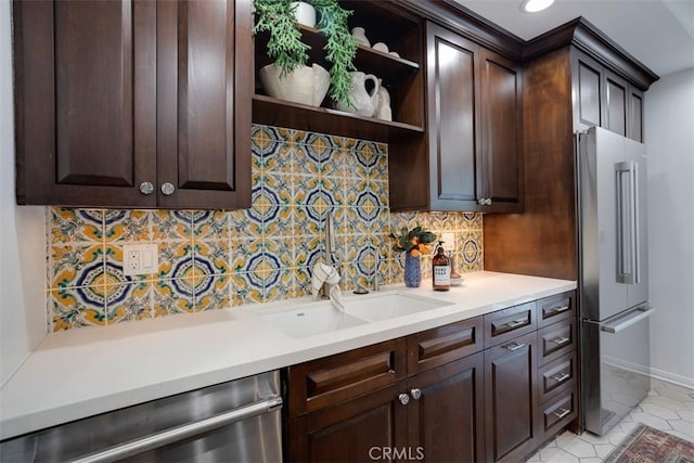 kitchen featuring sink, backsplash, dark brown cabinets, and appliances with stainless steel finishes