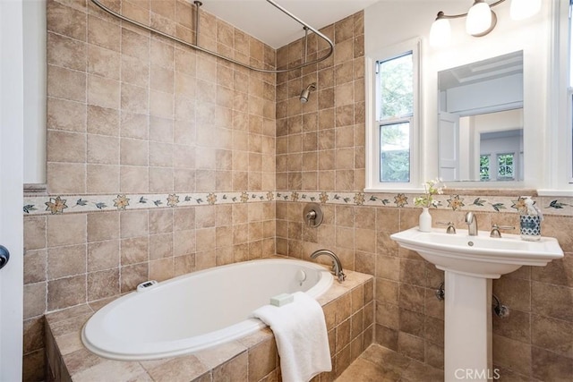 bathroom with tiled shower / bath and tile walls