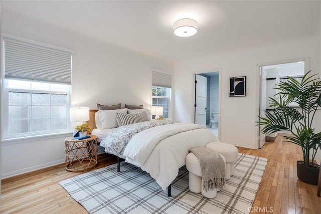 bedroom featuring ensuite bathroom and light hardwood / wood-style floors