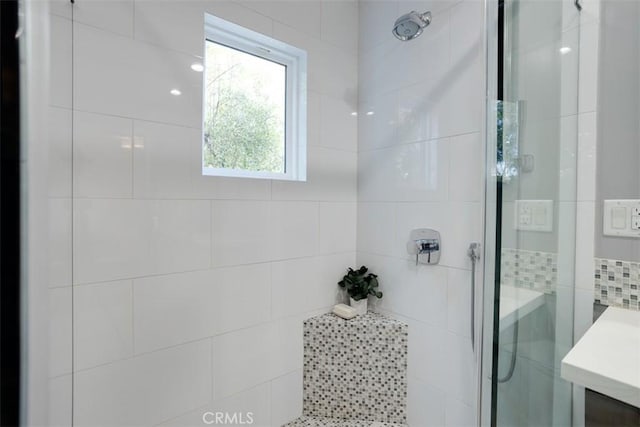 bathroom with vanity and tiled shower