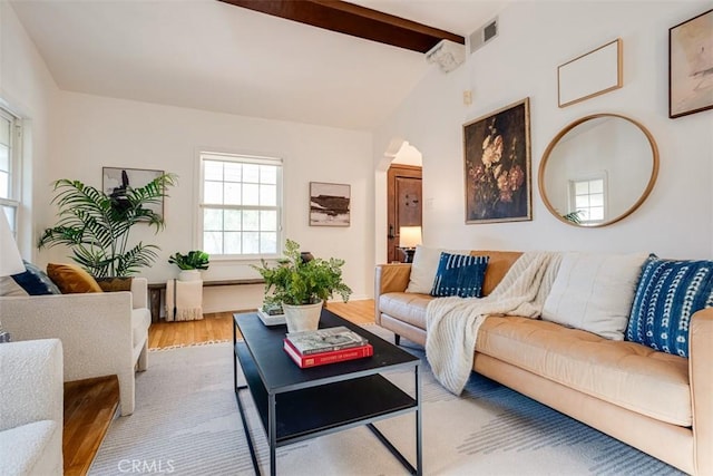 living room with hardwood / wood-style floors and vaulted ceiling with beams