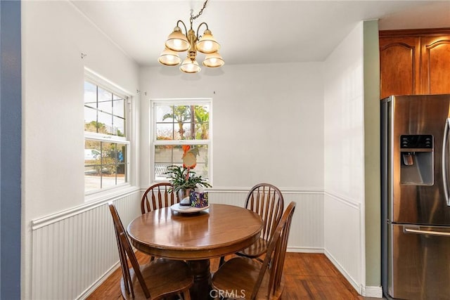 dining space with dark hardwood / wood-style floors and an inviting chandelier