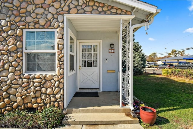 property entrance featuring a lawn