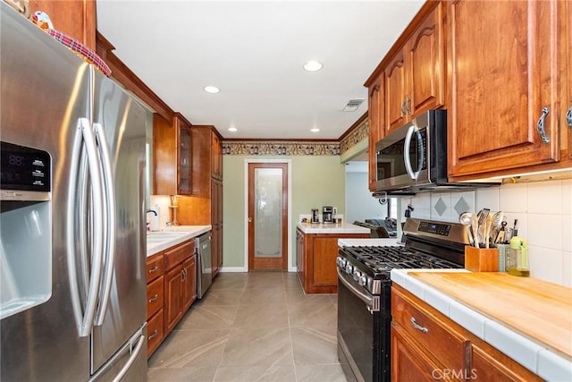 kitchen featuring stainless steel appliances, tasteful backsplash, and sink