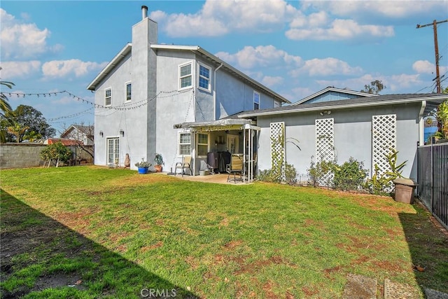 rear view of house featuring a yard and a patio