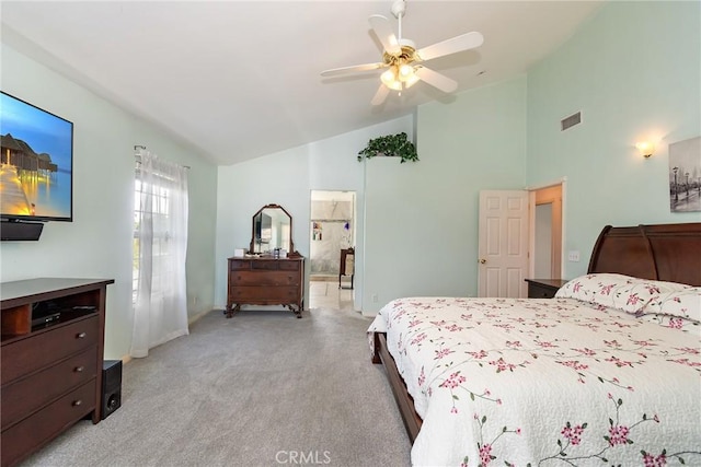 bedroom with ceiling fan, connected bathroom, high vaulted ceiling, and light carpet