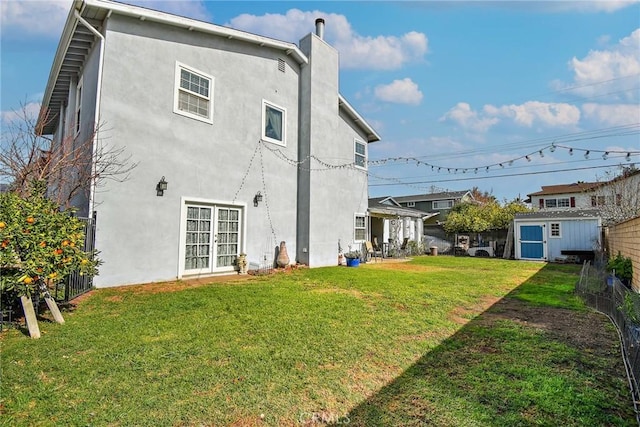 rear view of property with a shed and a lawn