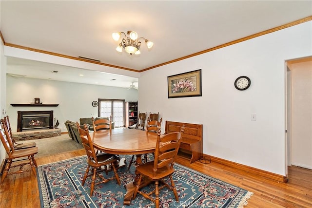 dining area featuring wood-type flooring, ornamental molding, and a chandelier