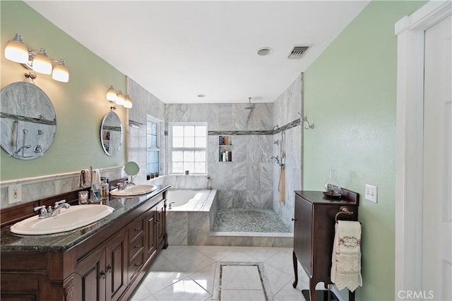 bathroom featuring independent shower and bath, vanity, and tile patterned flooring