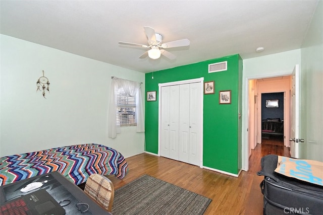 bedroom featuring hardwood / wood-style floors, ceiling fan, and a closet