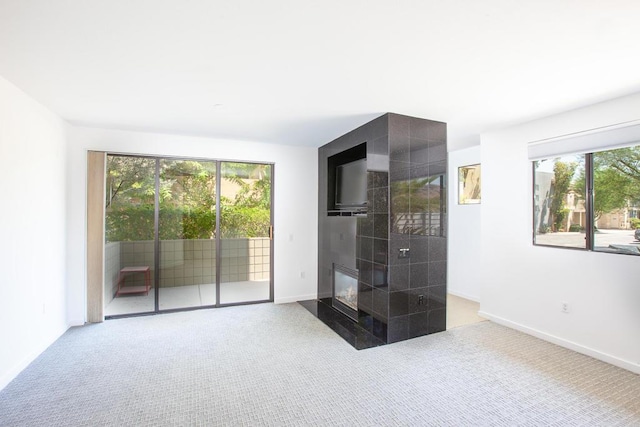 carpeted empty room with a fireplace