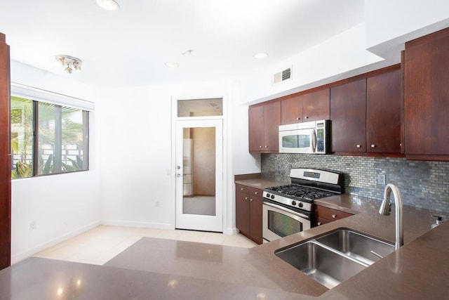 kitchen featuring dark brown cabinetry, sink, decorative backsplash, and stainless steel appliances