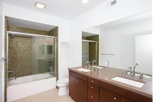 full bathroom featuring vanity, bath / shower combo with glass door, tile patterned floors, and toilet