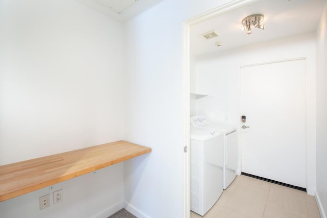 clothes washing area with light tile patterned floors and washing machine and clothes dryer