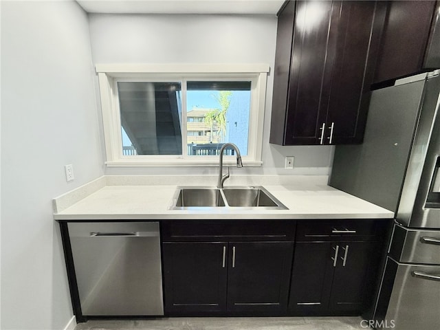 kitchen with dark brown cabinetry, sink, and appliances with stainless steel finishes