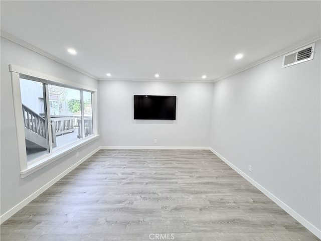 empty room with ornamental molding and light hardwood / wood-style floors