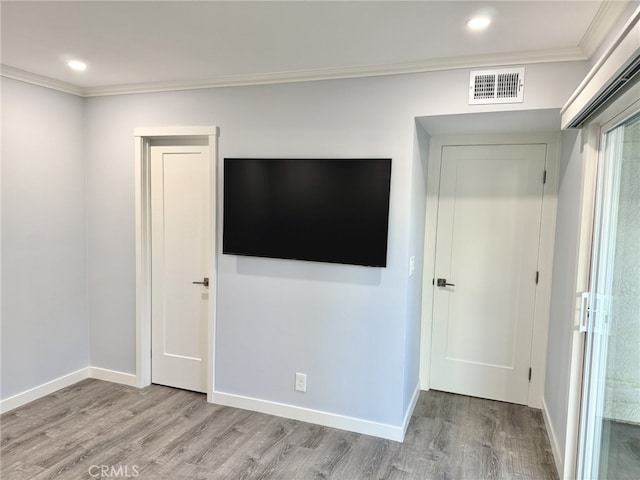 unfurnished bedroom featuring crown molding and light hardwood / wood-style floors