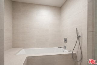 bathroom featuring tile walls and plus walk in shower