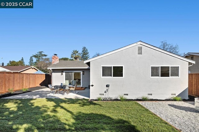 back of house with a lawn and a patio