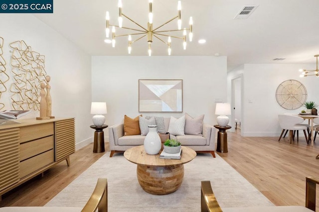 living room with hardwood / wood-style flooring and a notable chandelier