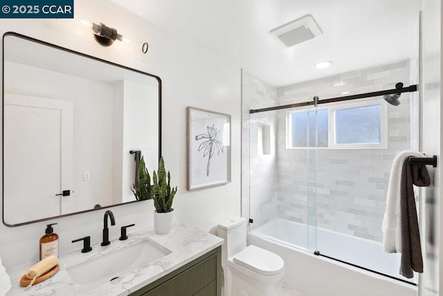 full bathroom with toilet, vanity, and bath / shower combo with glass door